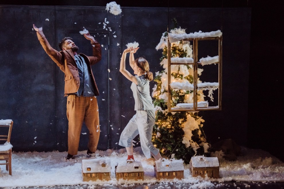 A production image from Heart of Winter with a man and a young girl playing with snow on stage